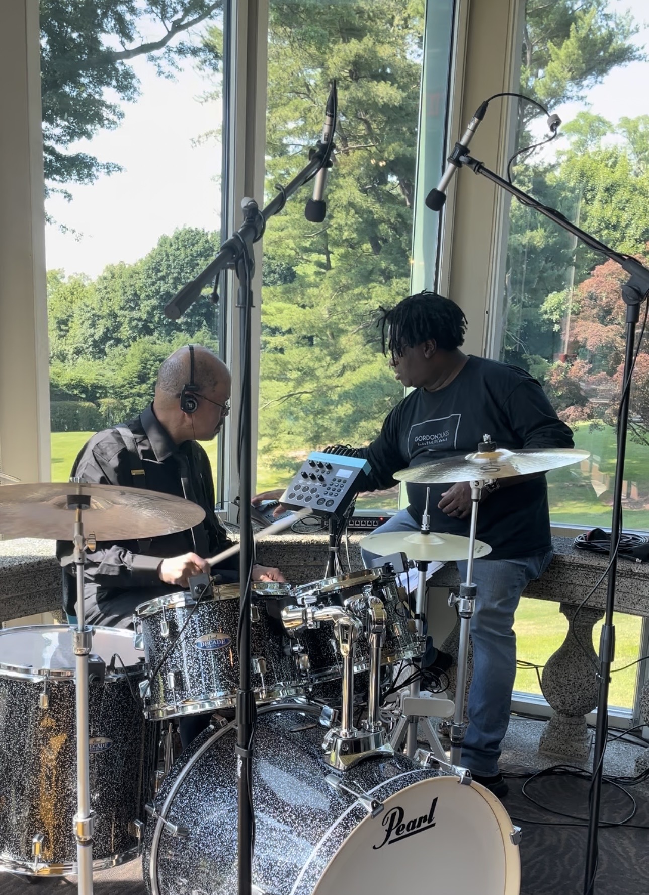 Gordon Dukes working through an arrangement with the drummer beside the kit before a performance