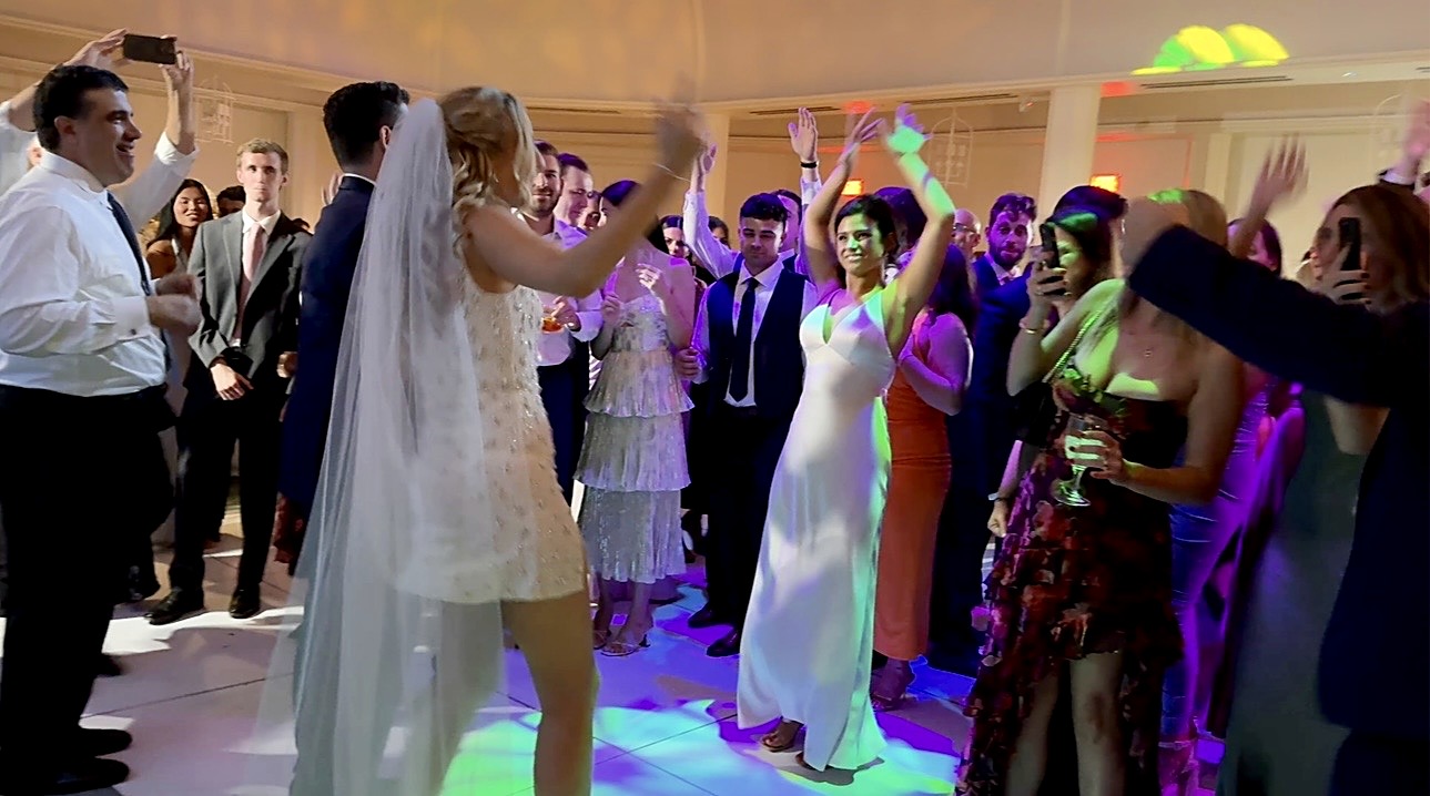 Katherine dancing in her veil at the centre of a circle of guests under coloured lights
