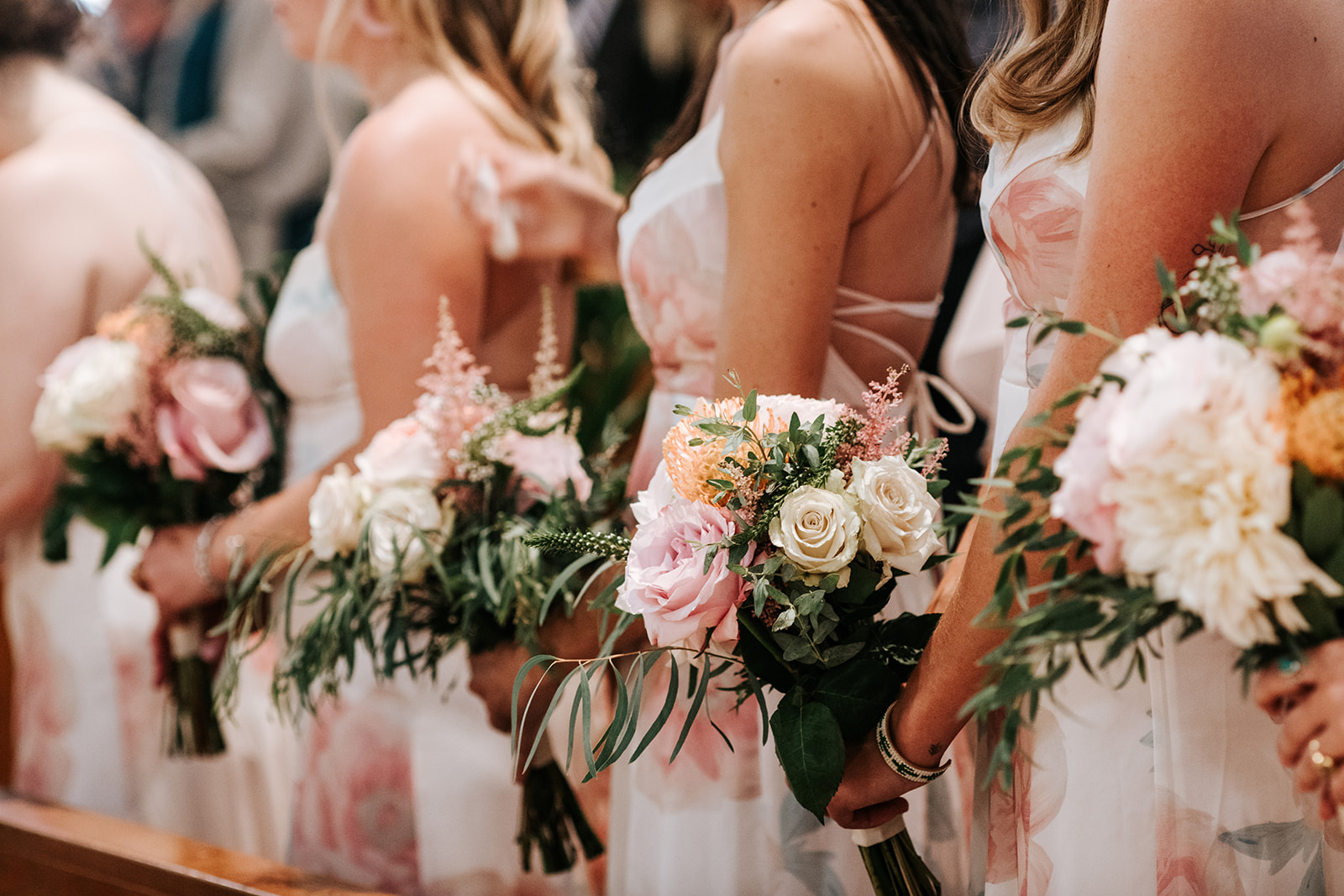 Bridesmaids holding bouquets at the aisle