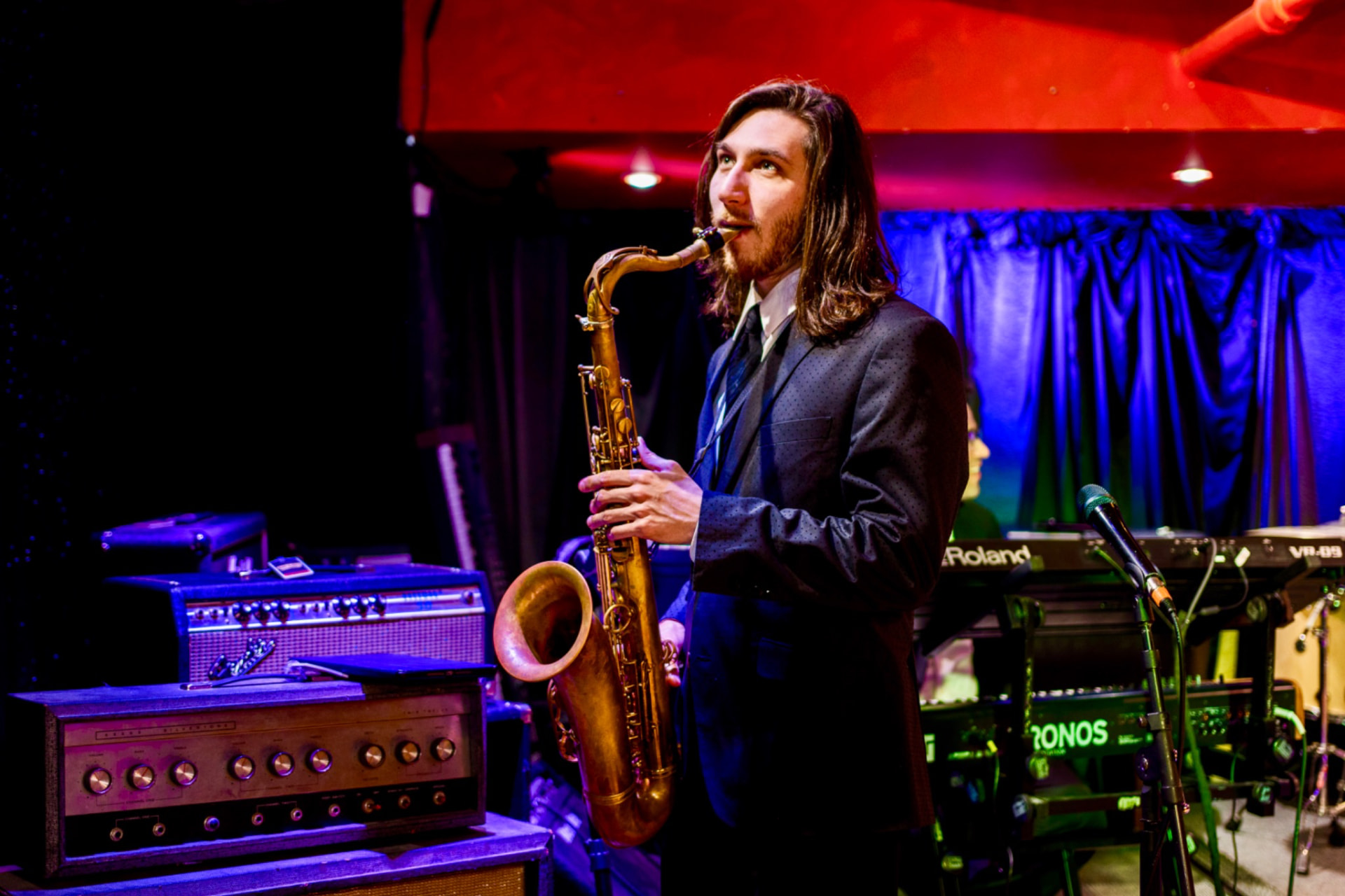 Gordon Dukes Music Company saxophonist playing a solo under stage light