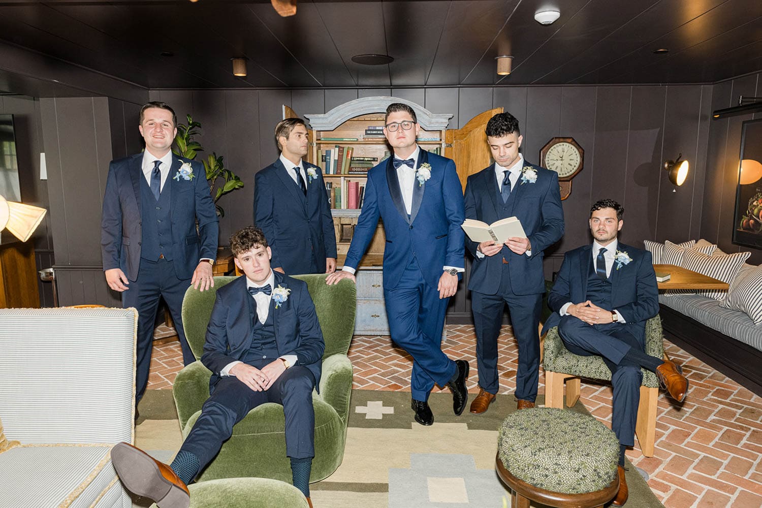 The groom and groomsmen in a library lounge before the ceremony