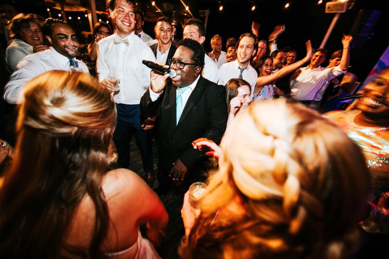 Gordon Dukes singing at the centre of the guests with The Best Wedding Band at Valentina and John's wedding in Montauk, New York