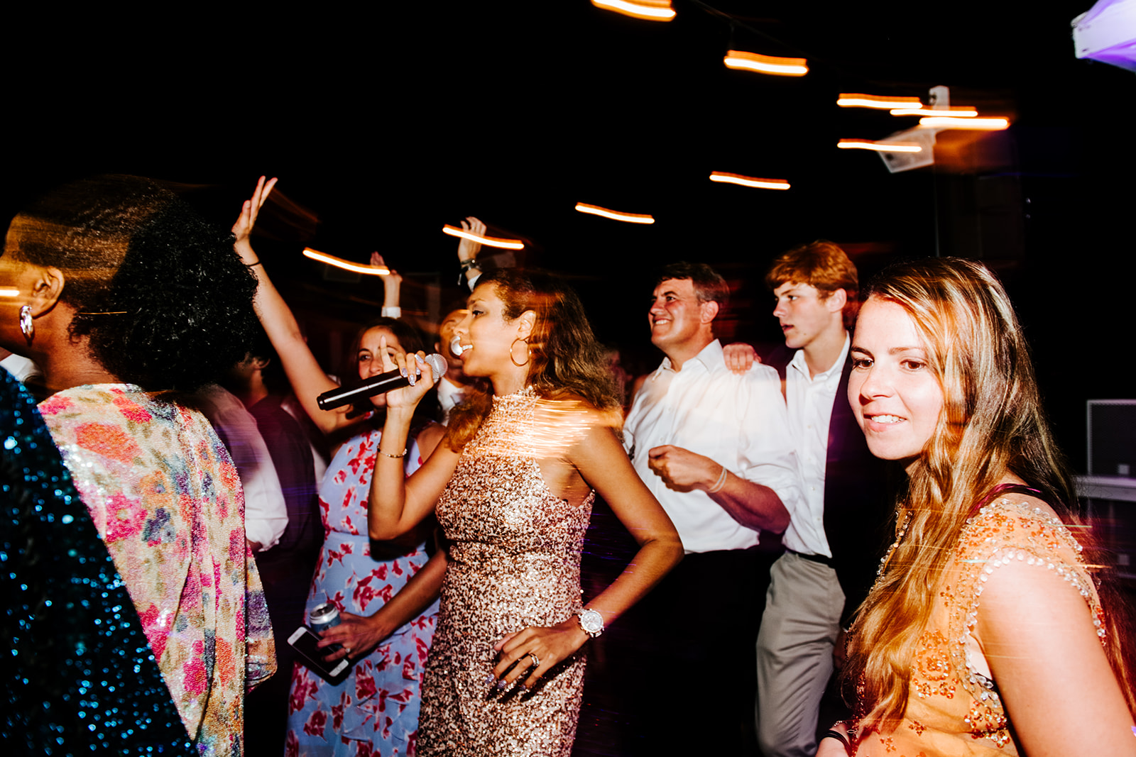 Vocalist in gold performing among the guests