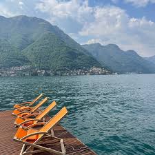 Lounge chairs on a private pier at Villa Lario overlooking the still waters of Lake Como.