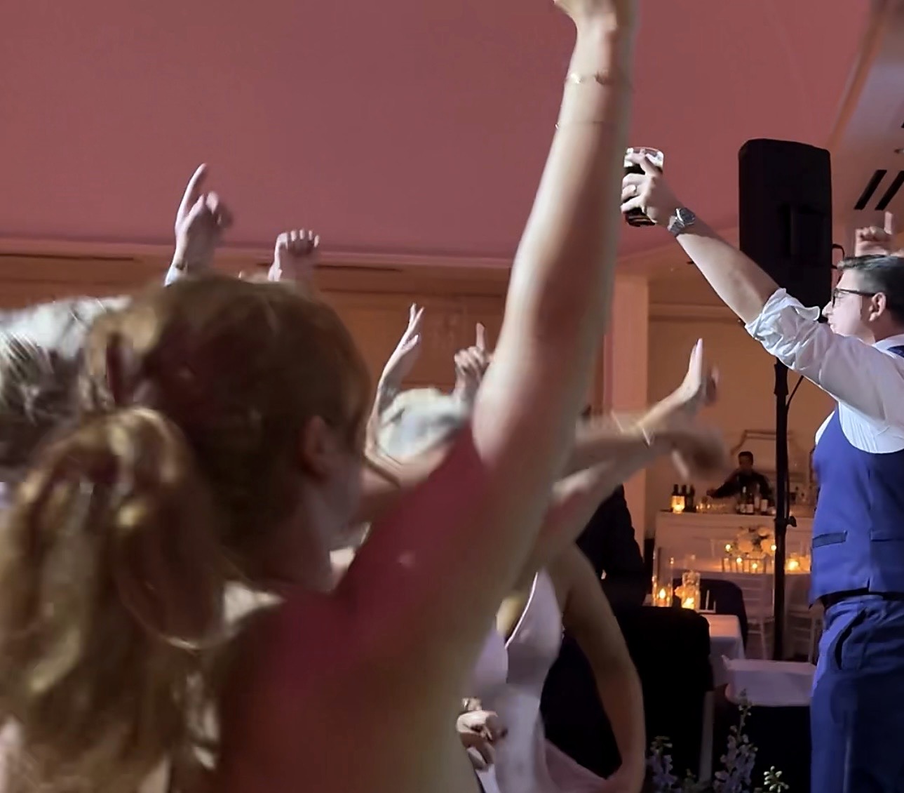 Guests with their arms in the air close to the stage as the band plays