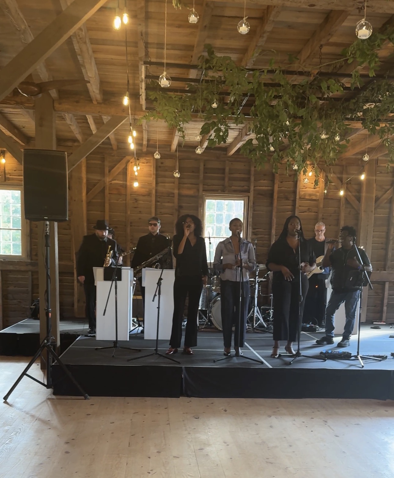 Gordon Dukes Music Company band and vocalists running a sound check on a barn stage under hanging lights