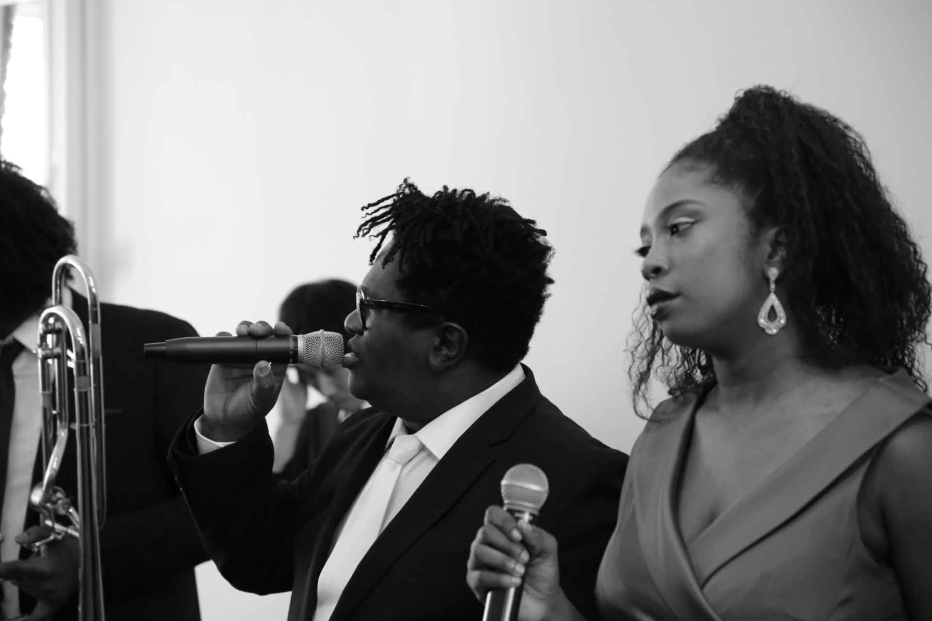 Gordon Dukes Music Company vocalists sharing a phrase on microphone, black and white