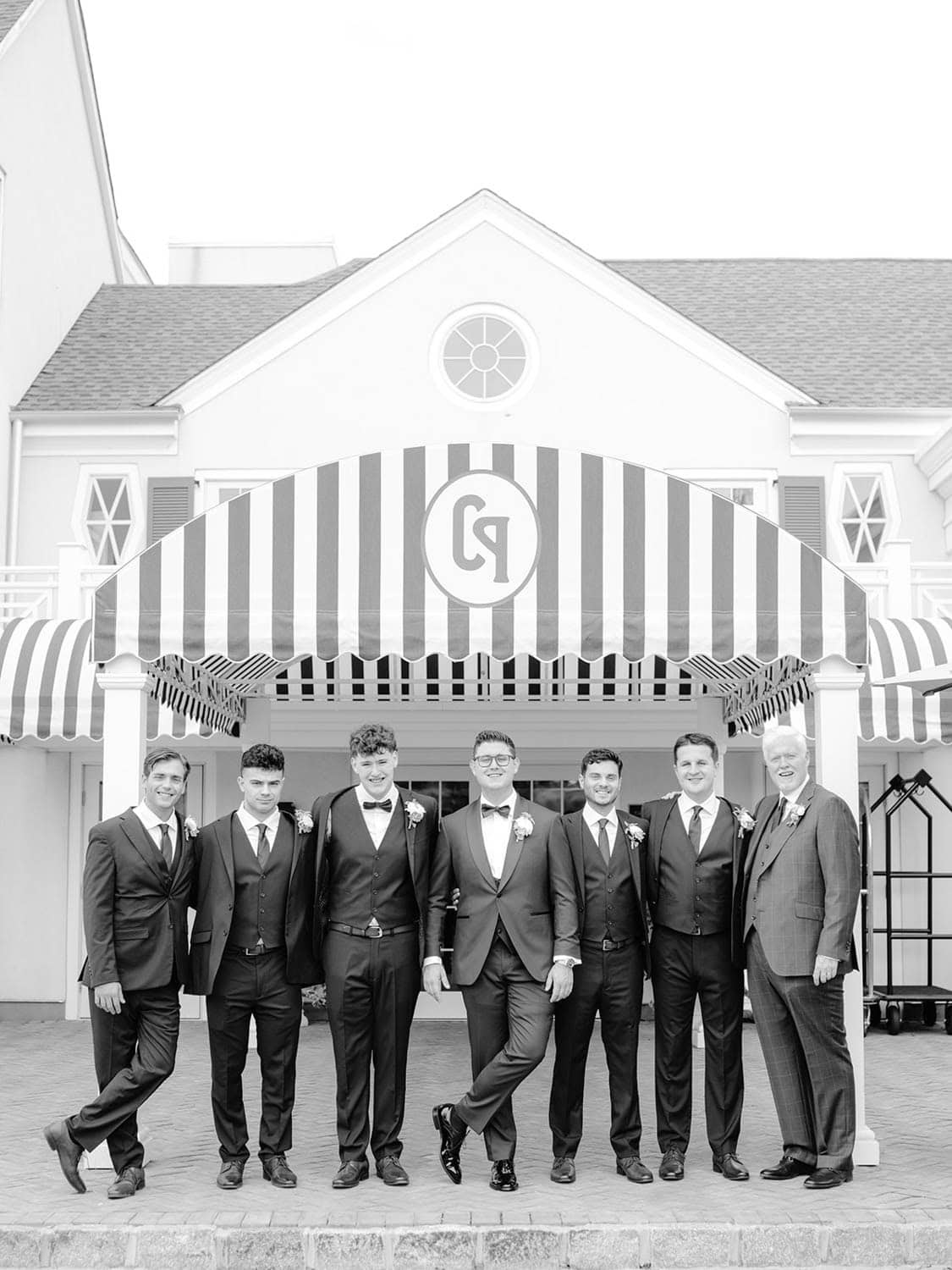 The groom and groomsmen in black and white outside the venue
