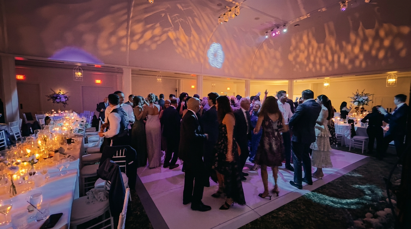 The tented ballroom at full celebration — candlelit tables framing the dance floor
